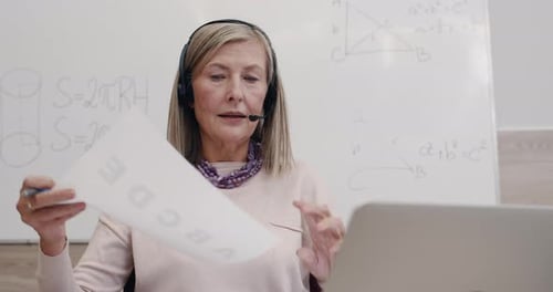 Close Up of Female Professor Talking and Holding Paper Sheet with Letters While Looking To Camera
