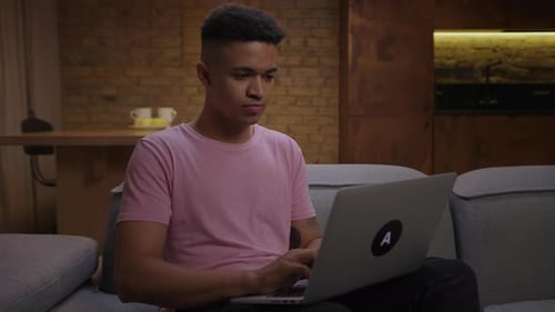 Young Adult Uses Laptop at Home