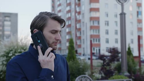Bearded Man Talks on His Black Phone