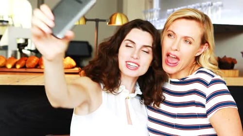 Two Women Taking Fun Selfies at Cafe