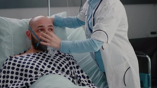 Patient Sitting in Bed While Woman Doctor Putting Oxygen Mask
