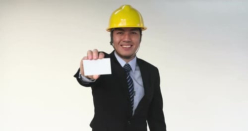 Businessman in Construction Helmet Showing Business Card