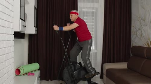Senior Man Exercising on Elliptical in Living Room