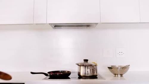 Woman Cooking in a Bright, White Kitchen