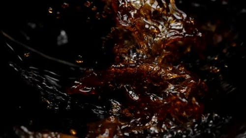 Dark Amber Fluid Splashing on Black Background