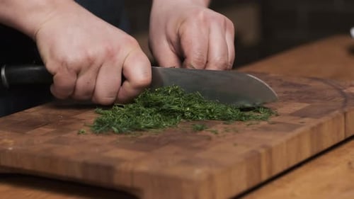 Close Up Chef in Restaurant Kitchen Cut Dill with Sharp Shiny Knife