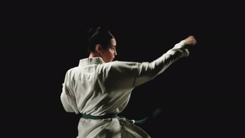 Woman Demonstrates Karate Punches and Kicks in Gi