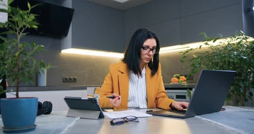 Mujer en ropa de negocios sentada frente a la computadora y trabajando