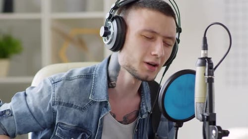 Young Adult Singing and Playing Guitar at Home