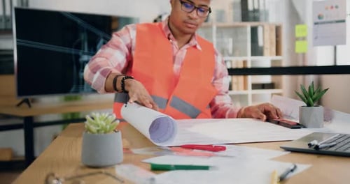 Ingeniero masculino con chaleco y casco hojeando el proyecto de papel del futuro edificio