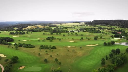 Green golf course with golf holes and little hills.