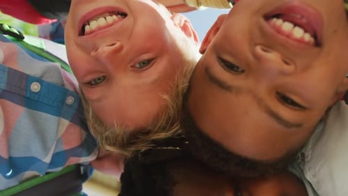 Video of low angle view of diverse boys hugging and laughing