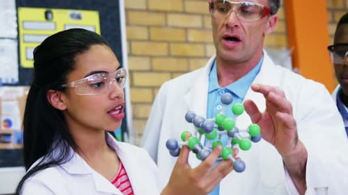 School teacher assisting schoolkids on molecule model 4k