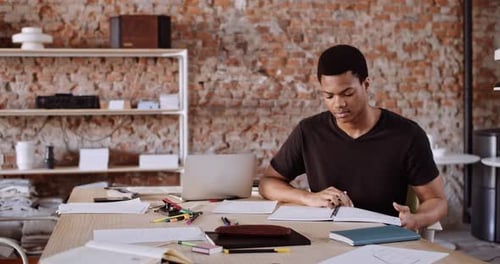 Focused Young Adult Studying at Desk in Urban Office