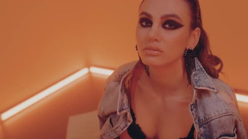 Fashionable Woman Posing in Orange Lit Room