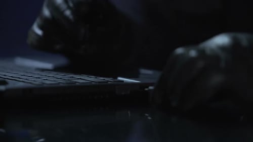 Hacker de sécurité connectant une clé USB avec un virus informatique à un ordinateur portable, cybercriminalité