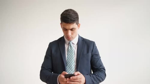 Happy Male Office Worker in Formal Clothes Uses Mobile Phone Rejoices in Victory
