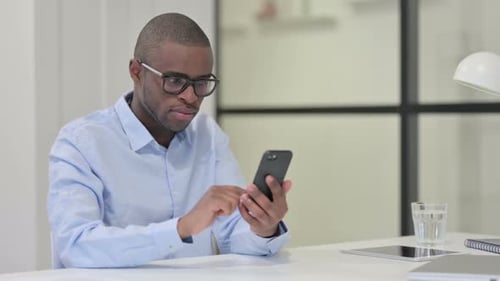 Man at Desk Using Smartphone