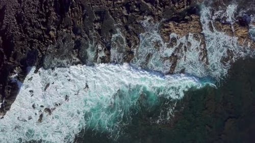 Overhead View of Waves Splash on Rocks