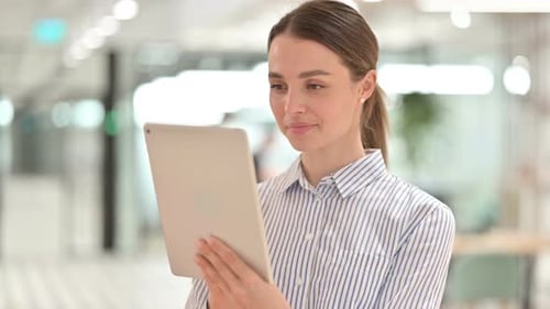 Woman Holding Tablet in Office Environment