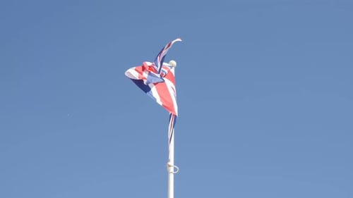 British Union Jack Flag Waving Against Blue Sky