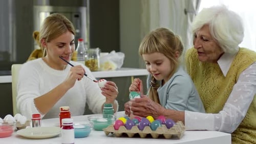 Family Painting Eggs for Easter Holiday