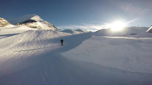 Young man skiing and doing tricks in terrain park on snow covered mountain.