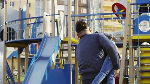 Fröhlicher kaukasischer Vater dreht sich mit Sohn im Freien herum