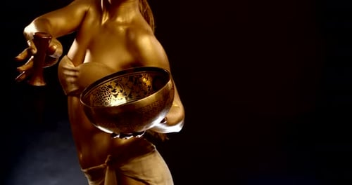 Woman Painted Gold Poses with Bowl and Mallet