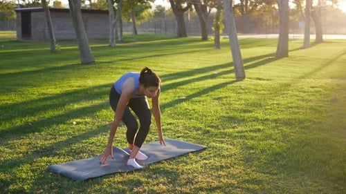 Woman Doing Yoga in Park at Sunrise
