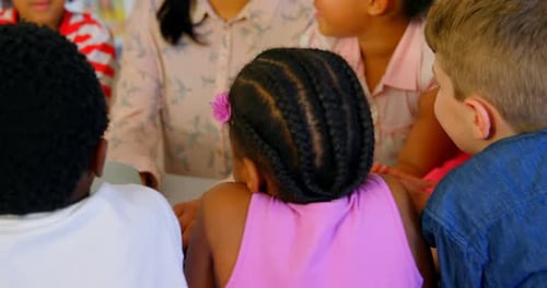 Asian female teacher teaching schoolkids in school library 4k