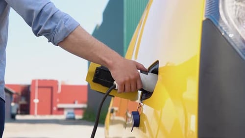 Unplugging Electric Yellow Van Charging Cable