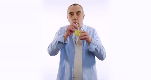 Man Drinking Yellow Beverage with Straw on White Background
