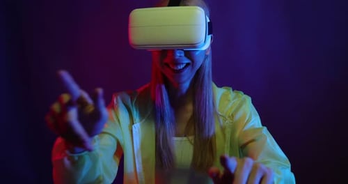 Young Asian woman playing metaverse virtual reality digital technology game with VR goggle.