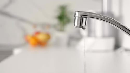 Leaky Faucet Drips Water in a Modern Kitchen