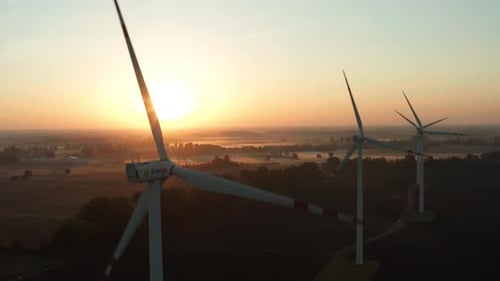 Aerial View of Large Wind Turbines at Sunrise with Fog