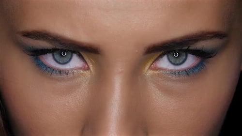 Girl Looks Fierce and Terrible Gaze Upwards. Close Up. Black Background