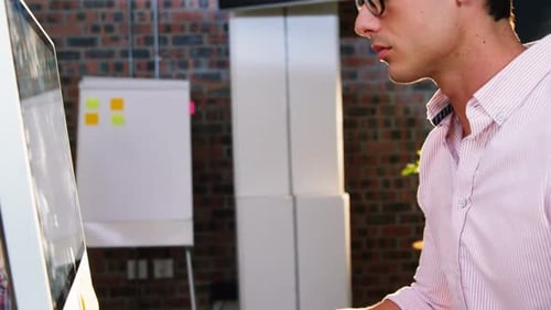Young Man Working at a Computer with a Tablet