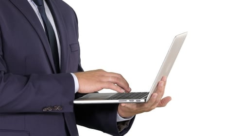 Man in Suit Typing on Laptop Computer