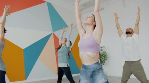 Serious Man and Women Busy with Yoga Asanas During Class in Modern Studio