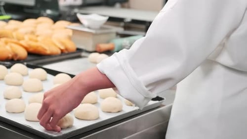 Chefs are preparing pastry dough, baking bakery food on a stainless steel table.