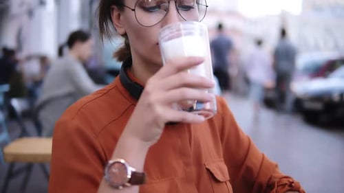 Beautiful Blonde Woman in Summer Cafe Gladly Drink Beverage with Foam