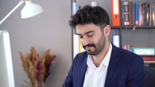 Glücklicher Mitarbeiter am Computer im Büro.