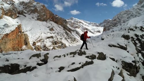 Lone Hiker Trekking Through Snowy Mountain Pass
