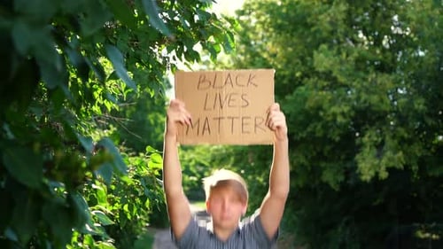 Teen Holding Black Lives Matter Sign Outdoors