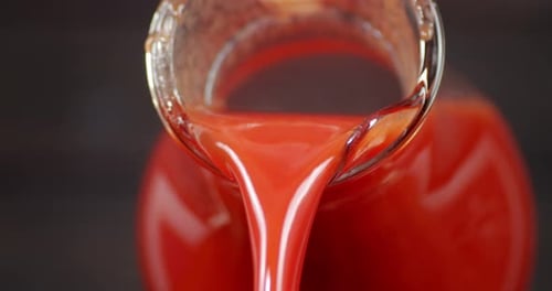 The Glass Jug Pours Tomato Juice.
