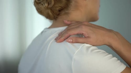 Woman Rubbing Her Shoulder and Neck Up Close