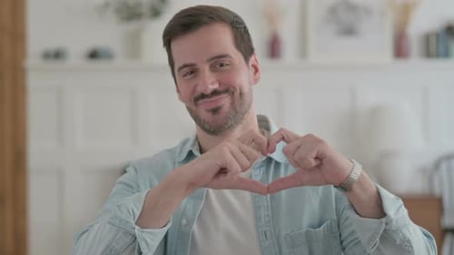 Man Forms Heart with Hands While Smiling