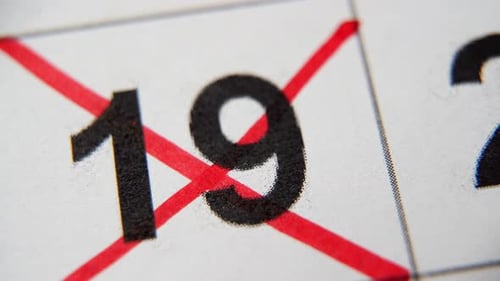 El número 19 del calendario está tachado con una cruz roja en una macro en una hoja blanca