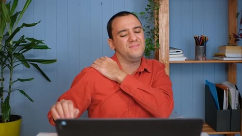 Man at Desk Rubbing Sore Shoulder